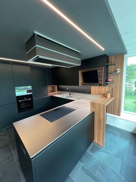Plan de travail inox posé sur une cuisine noir mat