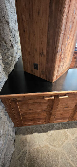 Plan de travail inox noir ajusté autour d'un montant en vieux bois