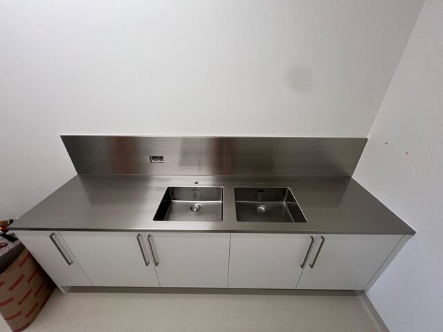 Plan de travail inox et crédence avec meubles blancs