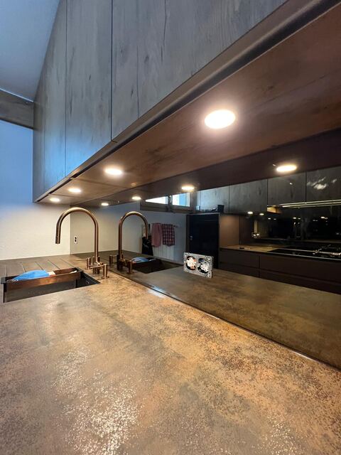 Plan de travail inox dans une cuisine sombre