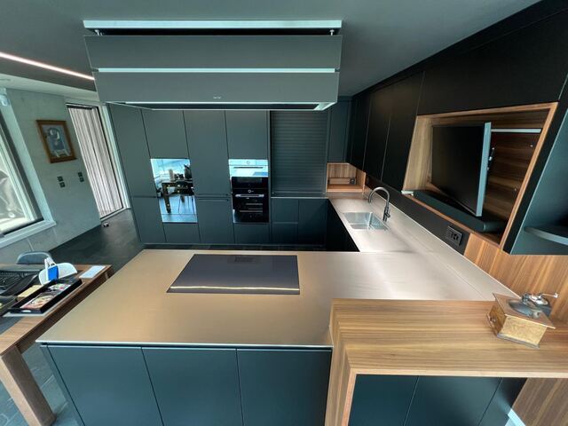 Plan de travail inox dans une cuisine en U avec bar en bois